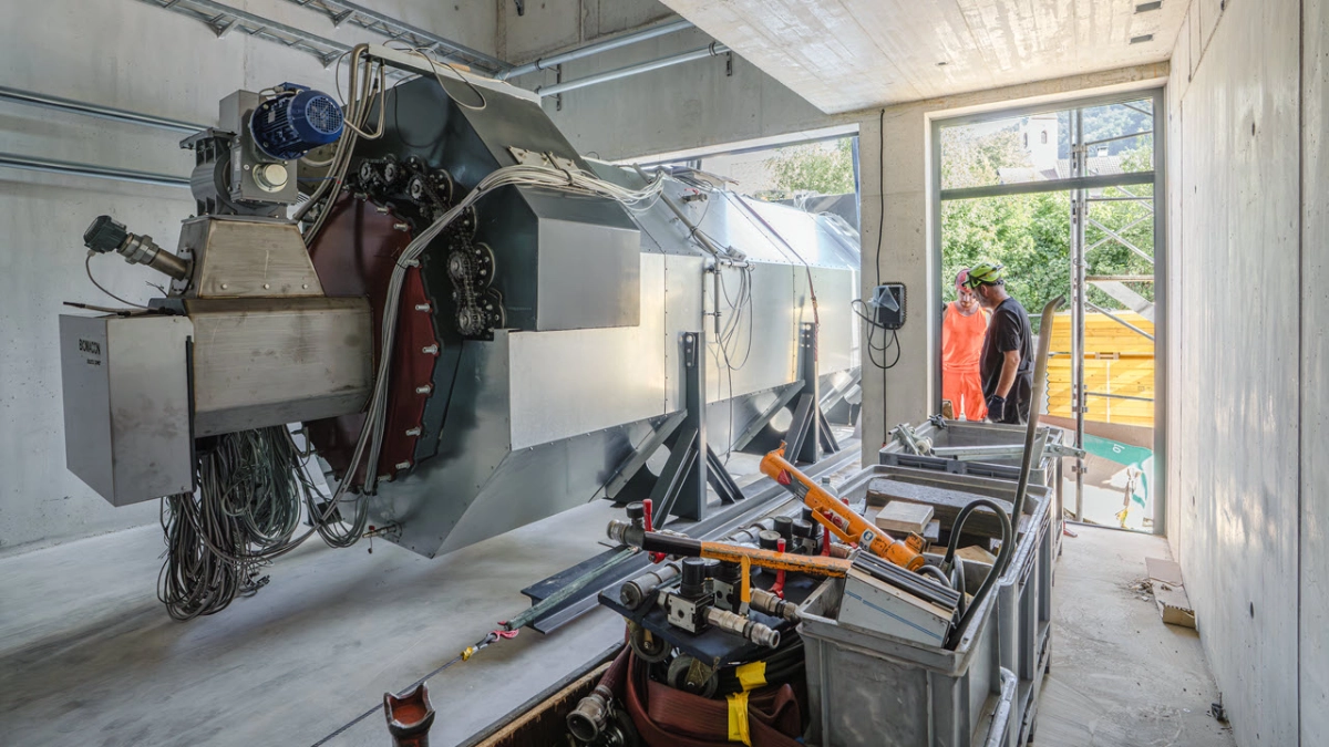 Eine silberne Anlage wird in ein Gebäude gehoben, Ansicht von innen.