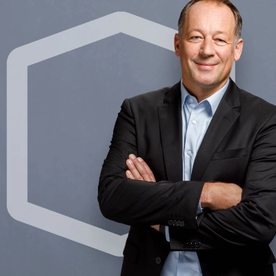 Geschäftsleitungsmitglied von IWB vor einer grauen Wand.