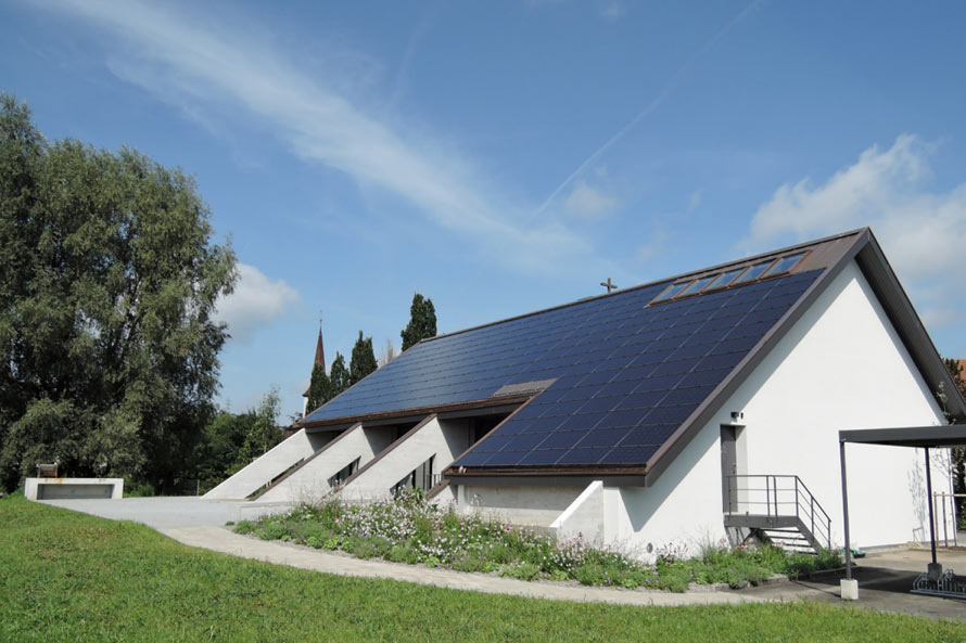 Ansicht vom Dach einer Kirche, auf dem nachträglich Solarpanels montiert wurden.