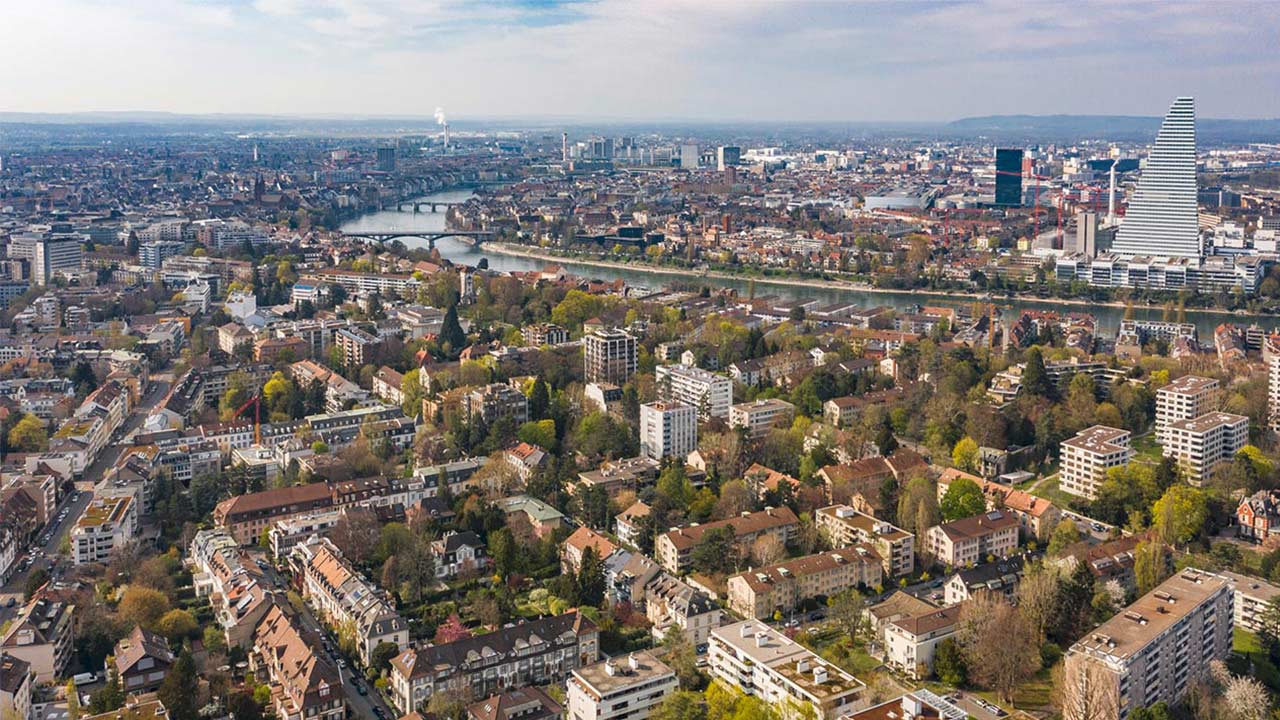 Basel-Stadt von oben mit wolkigem Himmel am Horizont