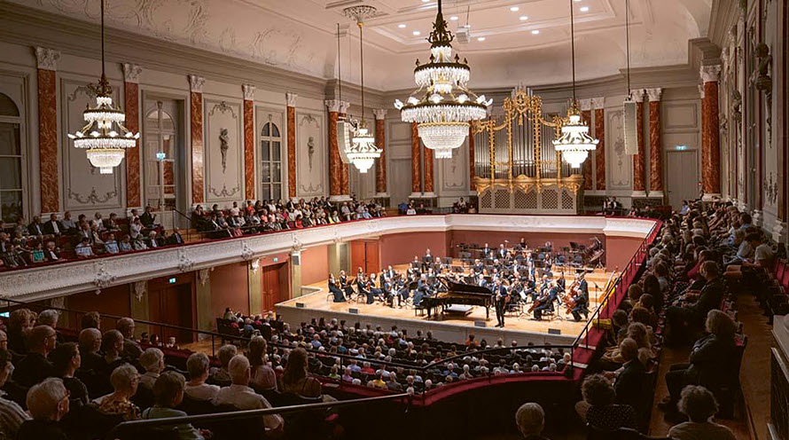 Konzertsaal im Stadtcasino Basel. Ein Orchester musiziert, das Publikum hört sitzend zu.