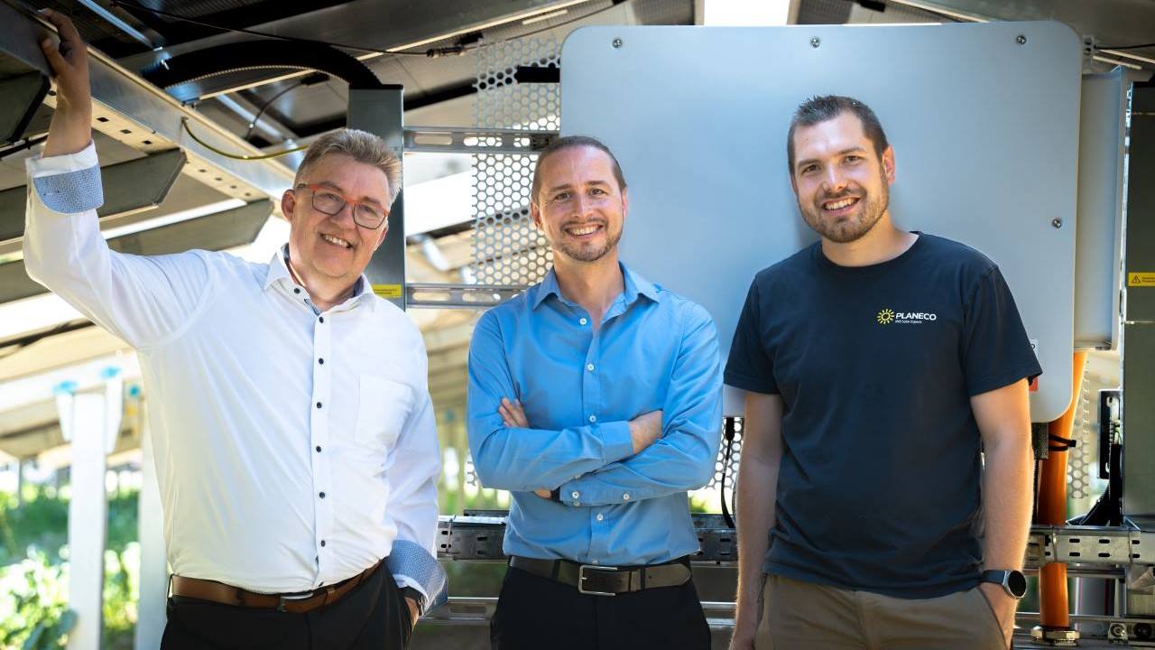 Drei Personen unter der Freiflächen-Solaranlage von Carbogen-Amcis.
