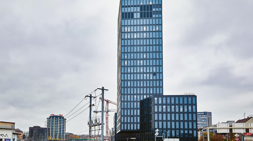 Ein Hochhaus in der Stadt. Der Grosspeter Tower in Basel hat eine Fassade, die Solarstrom erzeugt.