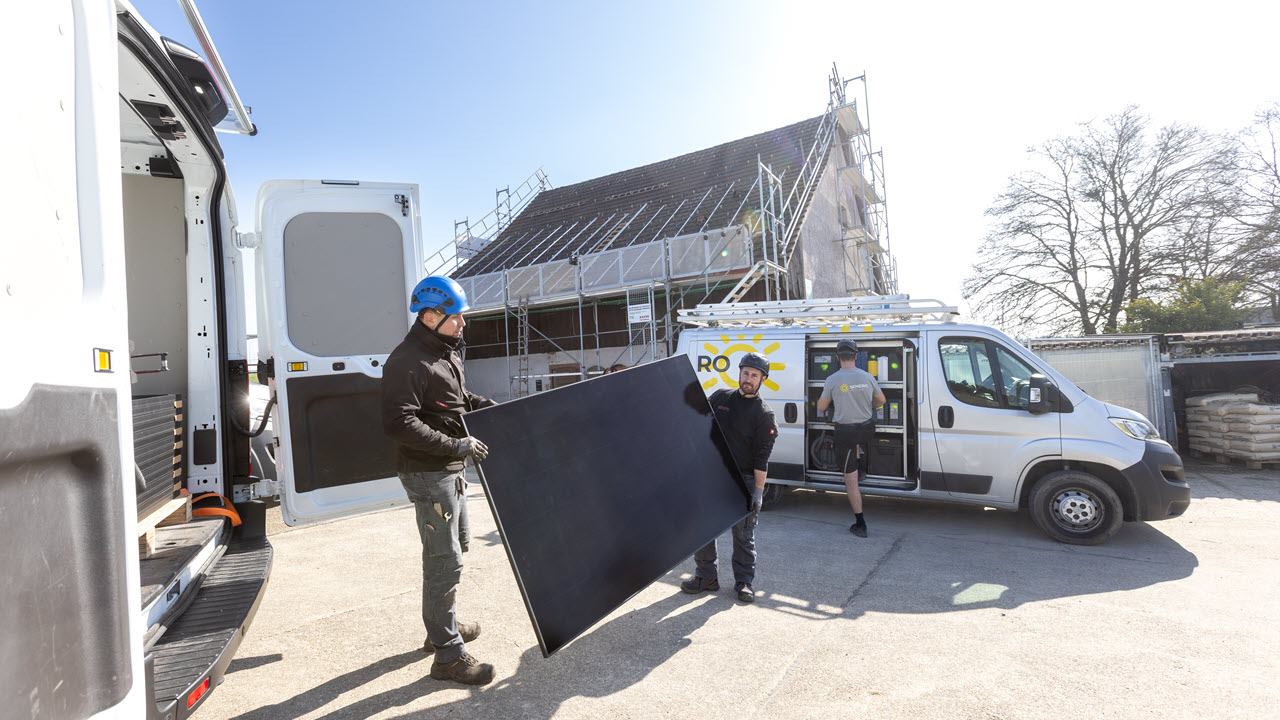 Zwei Senero-MItarbeitende laden ein PV-Modul ins Auto ein