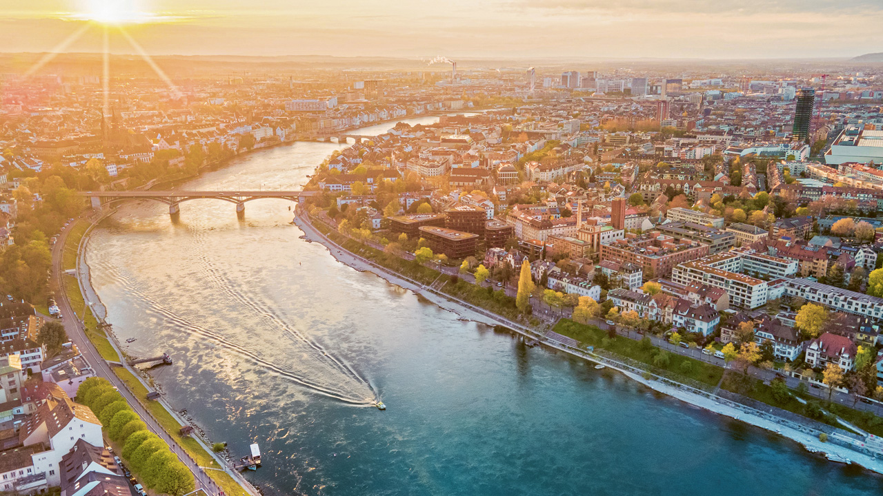 Blick aus der Vogelperspektive auf die Stadt Basel im Abendlicht.