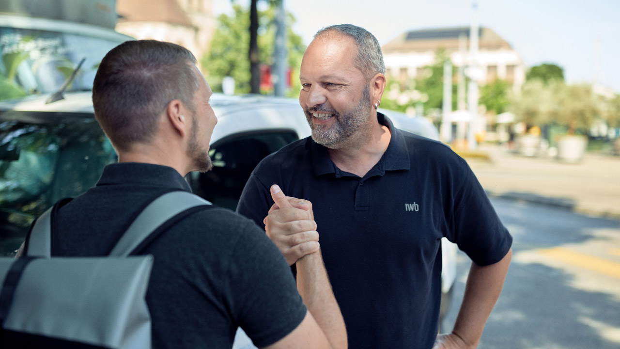 Philipp Frey und Pascal Jermann, zwei IWB Mitarbeitende, die sich einen Handschlag zur Begrüssung geben.