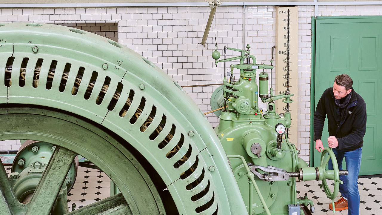 Ein Mann steht neben einer Turbine.