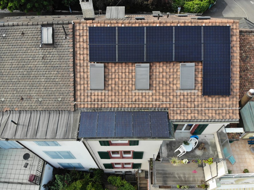 Ein Reihenhaus aus der Vogelperspektive. Auf dem Vordach und auf dem Ziegeldach wurde eine Solaranlage installiert.