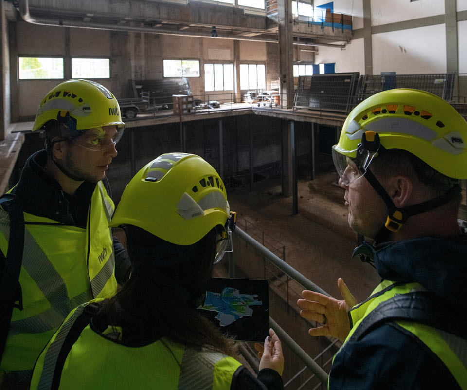 Philipp Frey, Ingela Lakatos und Beat Spengler stehen im Gebäude mit hoher Decke, wo künftig ein Multi-Fuel-Brenner sein wird.