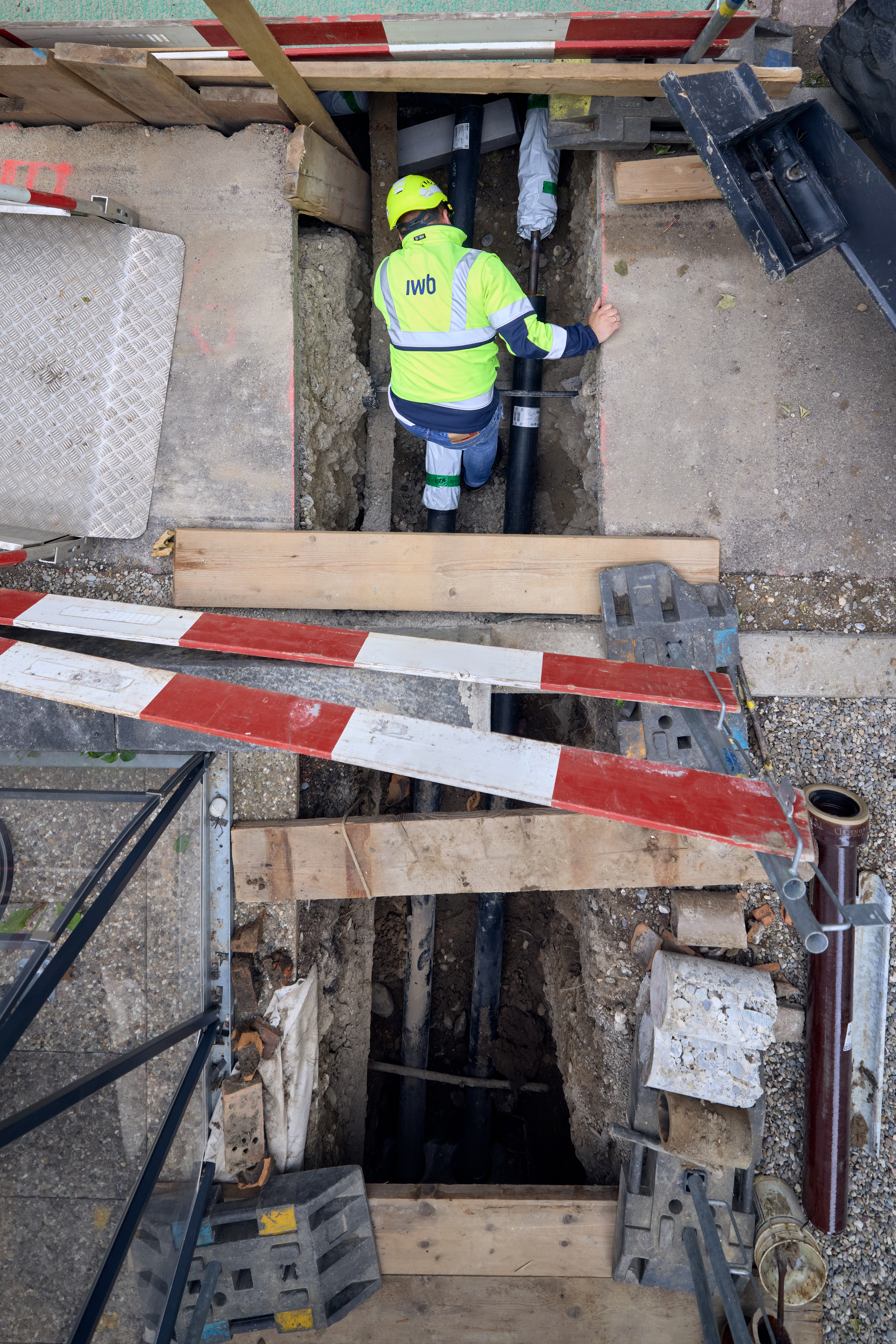 Arbeiter kontrolliert Installationen auf Fernwärme-Baustelle