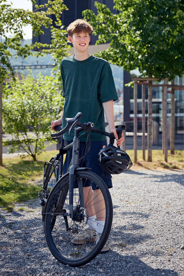 Janno Philipp Siegenthaler draussen mit seinem schwarzen Fahrrad.