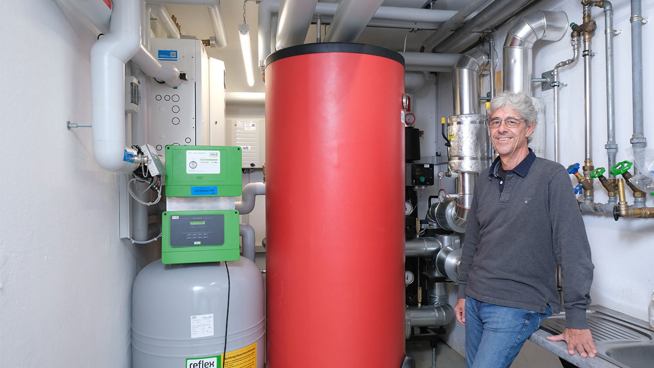 Mann steht vor der neu installierten Wärmelösung in der Waschküche