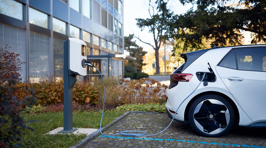 E-Auto lädt an Ladestation auf Parkplatz auf