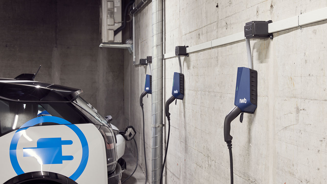 Ein E-Auto wird mit einer IWB Ladestation in einem Parkhaus aufgeladen.