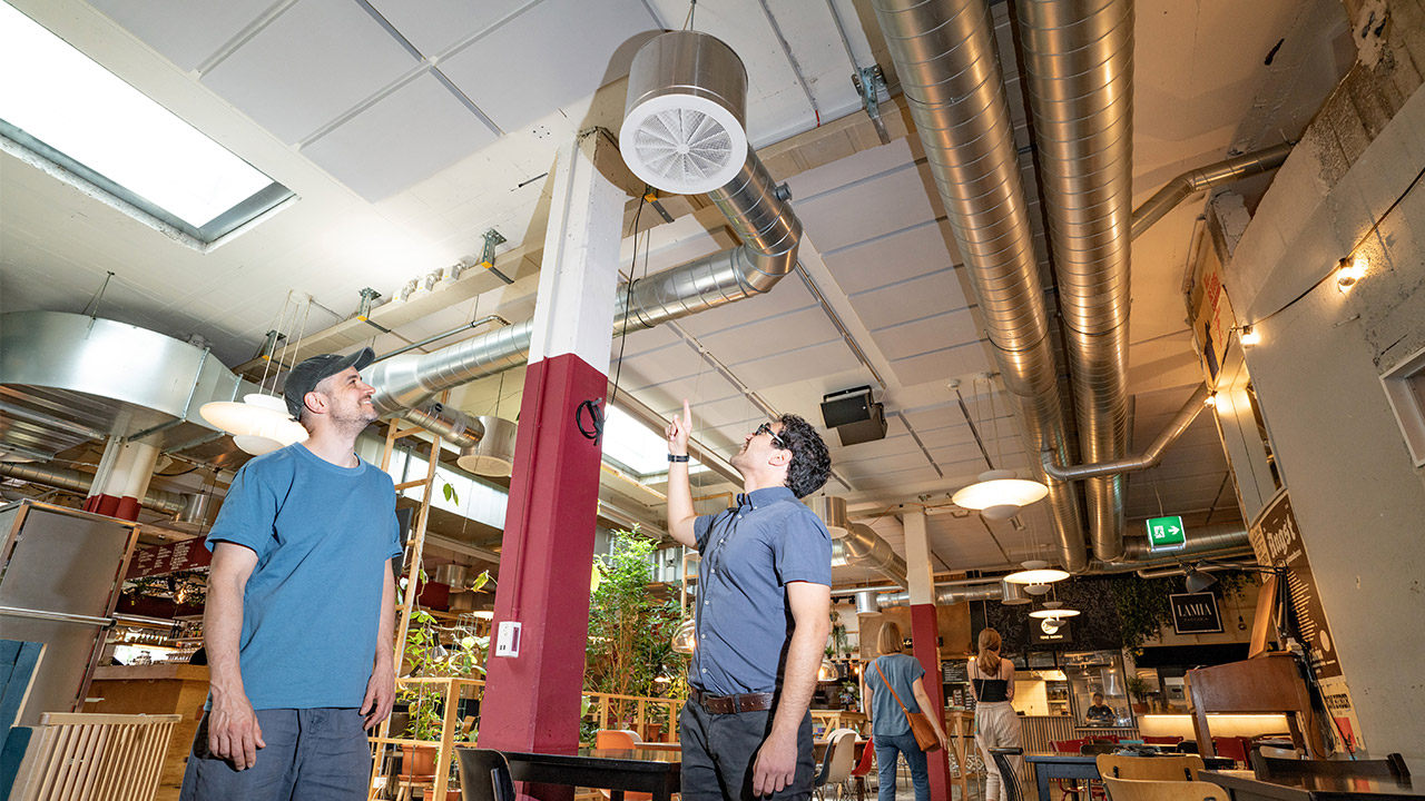 Nik von Frankenberg von Klara und Sandro Onorati von IWB begutachten den Lüftungsventilator im Gebäude von Klara.